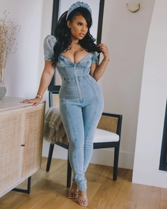Detail of light blue denim romper with puffed sleeves and a front zipper closure