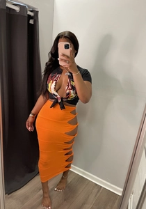 Detail of orange knitted skirt with side cut-out knots and graphic crop top