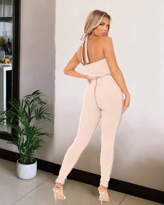 Detailed back view of a beige halter jumpsuit with rib-knit texture and open back design