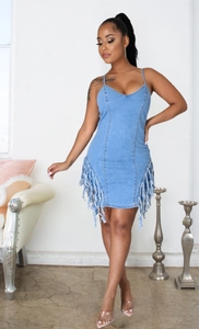 Détail d'une robe midi en jean bleu clair avec finitions à franges et coupe ajustée