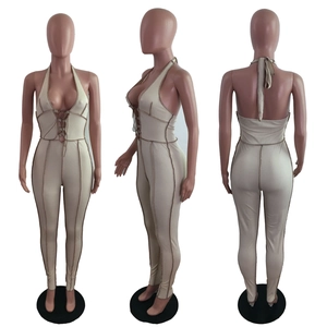 Detailed views of a beige ribbed knit halter neck jumpsuit with contrast stitching and ties
