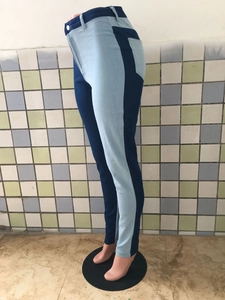Detail van een skinny jeans met hoge taille, blauwe patchwork en slanke pasvorm