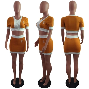 Detail view of orange and white contrast stitch crop top and mini skirt two-piece set