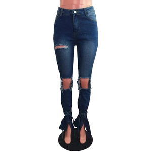 Dettaglio di jeans skinny blu strappati con spacchi laterali e fiocchi in nastro eleganti