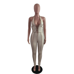 Detailed view of beige ribbed halter neck jumpsuit with cross-tie front and contrast stitching