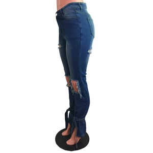 Dettaglio jeans a zampa blu con strappi sulle ginocchia e lacci regolabili sul fondo