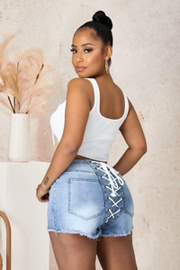 Détail du short en jean bleu clair avec laçage au dos et ourlet effiloché