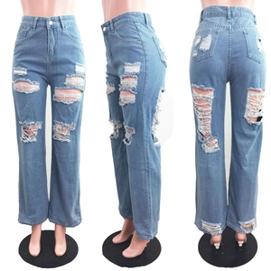Dettaglio dei jeans azzurri a gamba larga con strappi, texture consumata e vita alta