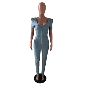 Detail view of denim jumpsuit with puff sleeves and front zipper on mannequin