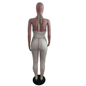 Detail of light khaki halter neck backless jumpsuit with ribbed texture on a mannequin