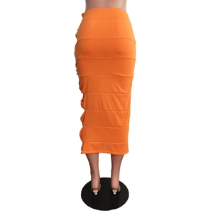 Detail of orange midi skirt featuring lateral panels and side cut-out with ruched texture
