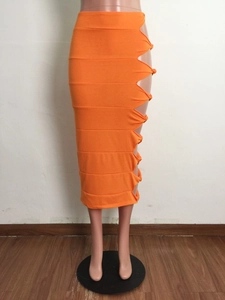 Detail of orange hollow out knotted midi skirt showing elastic textured fabric and side cut-outs
