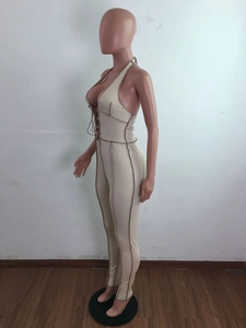 Detail view of beige ribbed jumpsuit with halter neck and contrast stitching details