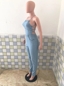 Détail d'une combinaison en jean bleu clair avec dos nu à lacets croisés et ourlets effilochés