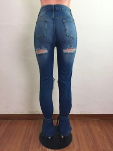 Dettaglio dei jeans a vita alta blu scuro con tasche posteriori e dettagli strappati