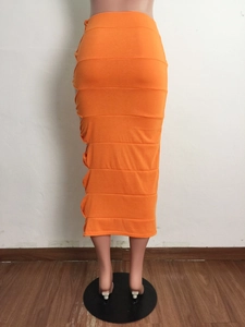 Detail of orange ruched midi skirt featuring layered stitching and drawstring design