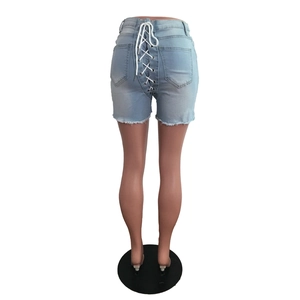 Détail de short en jean bleu clair taille haute avec laçage croisé blanc à l'arrière