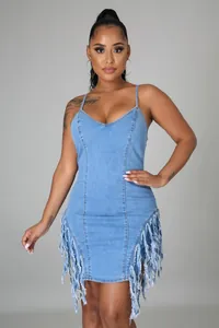 Détail de la robe en jean bleu clair montrant l'ourlet à franges et les bords effilochés