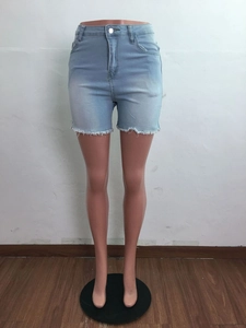 Gros plan sur un short en jean taille haute bleu clair avec bords effilochés et lacets latéraux