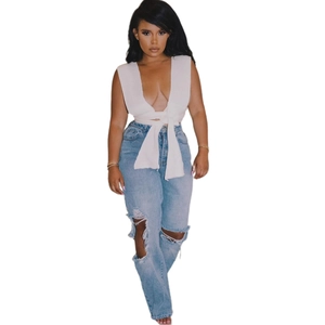 Haut court blanc à col en V avec un jean bleu clair délavé et déchiré pour femmes