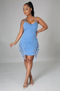 Gros plan détaillé sur l'ourlet à franges et les textures de cette robe en jean bleu