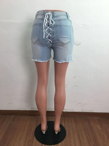 Détail du short en jean bleu clair avec laçage au dos et bords bruts effilochés