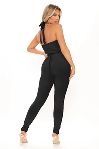 Detail view of a black ribbed halter neck jumpsuit with a stylish backless design