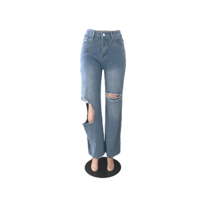 Gros plan d'un jean bleu clair à taille haute avec de larges déchirures de style usé