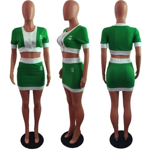 Detail view of green crop top and mini skirt set with white contrast trim and logo