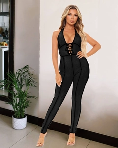 Detail of black halter jumpsuit featuring a deep V-neckline and front lace-up design