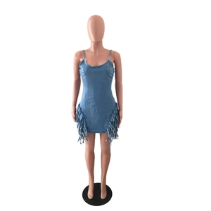 Détail de la mini-robe en jean bleu clair avec des franges latérales et bords effilochés