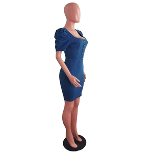 Detail of slim fit denim mini dress with puff sleeves and metal button down closure
