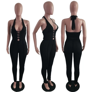 Detail of black halter neck jumpsuit featuring plunging V-neck and lace-up front details