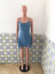 Détail de la robe en jean bleue avec ourlet à franges et texture en denim délavé