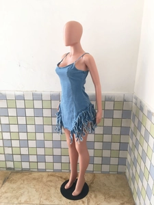 Détail de la robe en jean bleue avec ourlet à franges et coupe ajustée sans manches