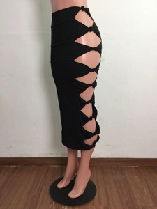 Detail of sexy black midi skirt featuring hollow-out side cutouts and knot tie details