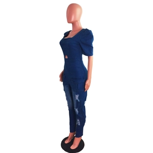 Detail of slim-fit denim jumpsuit with puff sleeves and distressed knee cutouts