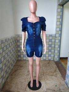 Détail d'un combishort en jean bleu foncé avec manches bouffantes et encolure carrée