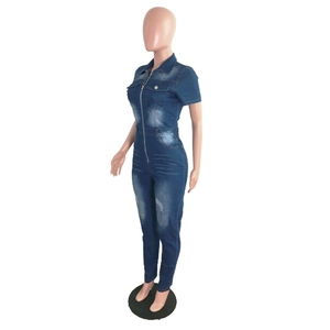 Détail d'une combinaison en jean bleu foncé avec zip métallique et texture délavée