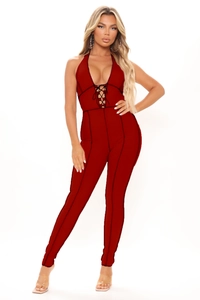 Detail of burgundy halter neck jumpsuit with black cross lace-up design and contrast stitching