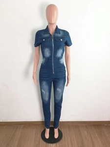 Détail de la combinaison en jean ajustée avec fermeture zippée et poches poitrine classiques