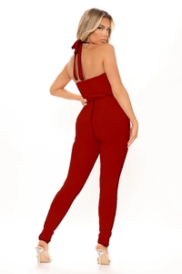 Detail showing the red ribbed knit texture and backless halter neck design of the jumpsuit