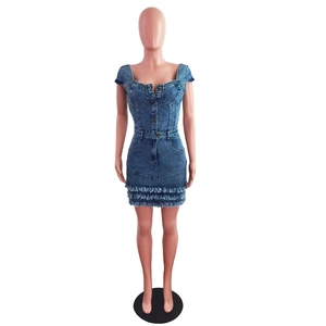 Dettaglio dell'abito in denim blu con scollo a cuore e orlo con frange grezze