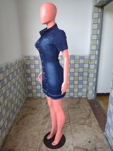 Detail shot of mid-blue denim dress showing metal buttons and distressed frayed hemline