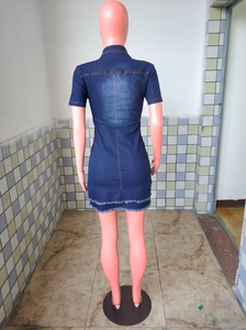 Detail view of denim dress featuring double-layered fringed hem and distressed wash texture