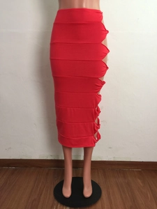 Detail of red bandage midi skirt featuring side cut-outs and intricate knot accents