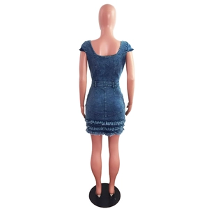 Vista posteriore dell'abito in denim aderente con schiena scoperta e orlo con frange