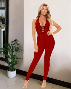 Detail of deep red ribbed halter jumpsuit with sexy cross-strap and plunging V-neck design