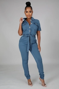 Detail of short sleeve dark blue denim jumpsuit featuring lapel collar and belted waistline