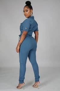 Detailed view of women's short sleeve denim jumpsuit with waist tie and button cuffs